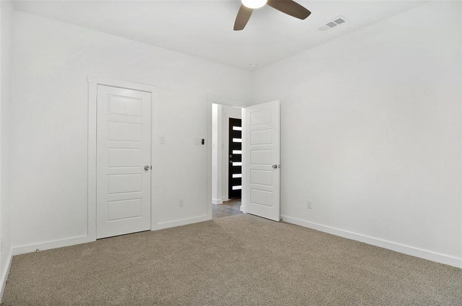 Unfurnished room with light colored carpet and ceiling fan