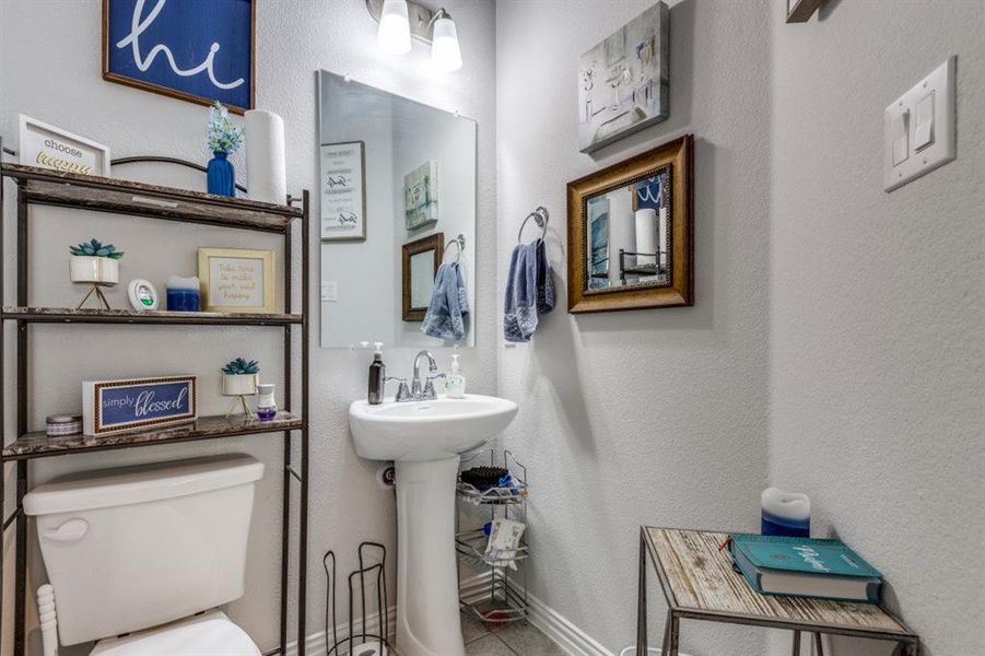 Bathroom featuring tile patterned floors, sink, and toilet