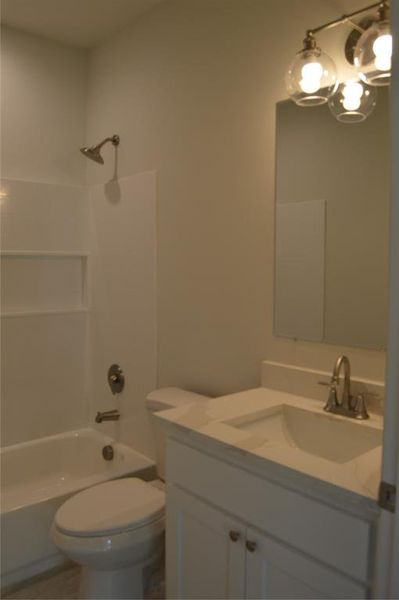 Full bathroom featuring toilet, vanity, and tub / shower combination