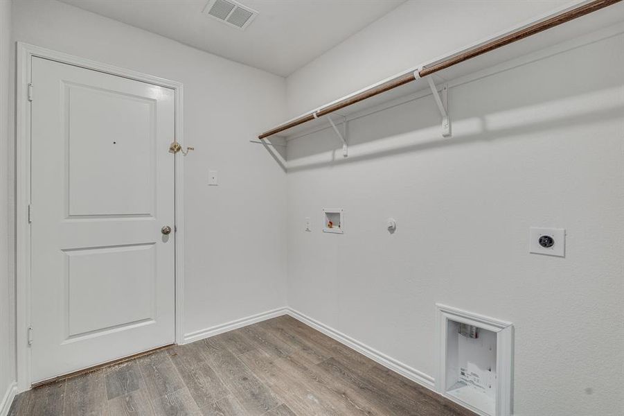 Laundry area with washer hookup, hardwood / wood-style flooring, hookup for a gas dryer, and hookup for an electric dryer