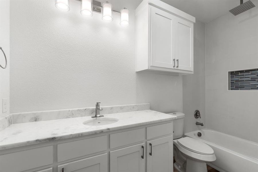 Full bathroom with vanity, shower / bath combination, and toilet