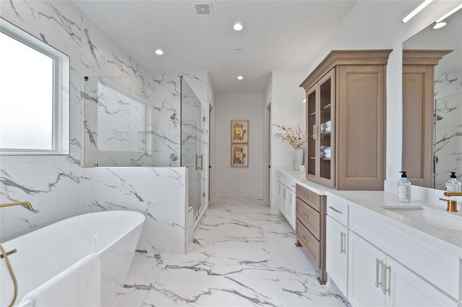 Spa inspired extra large bathroom features custom Benedettini cabinetry and premium Moen faucets.