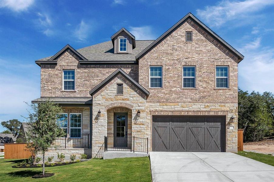 The Wilson plan at The Colony is a beautiful two-story home with a long driveway, gorgeous cedar garage door, and lush front yard landscaping.