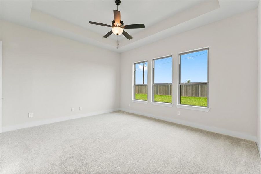 Primary Bedroom with Coffered Ceiling, Wall of Windows and Fan