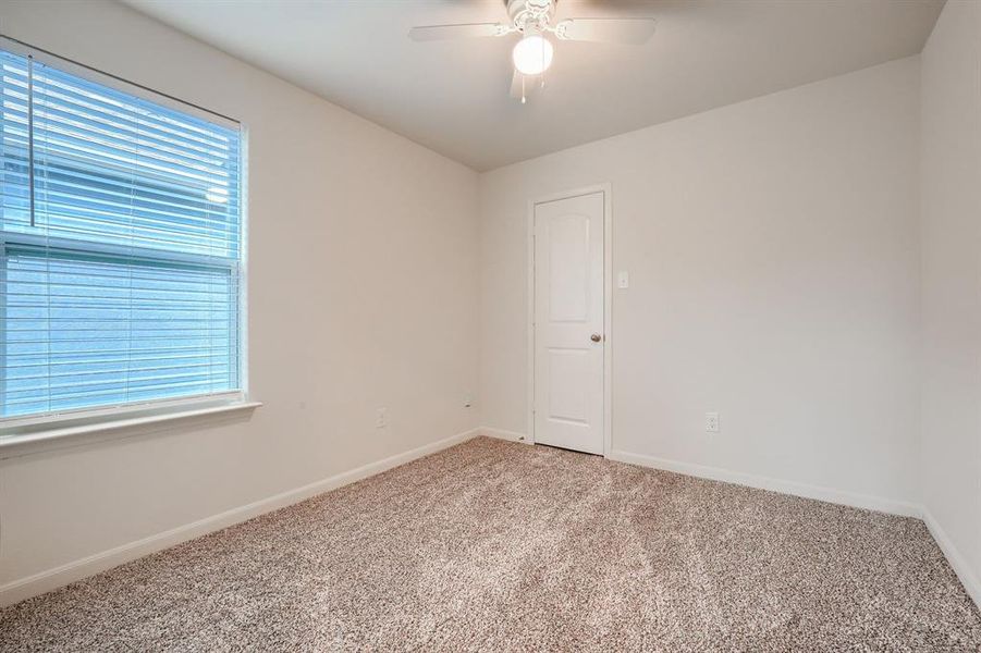 Spare room with a healthy amount of sunlight, carpet flooring, and ceiling fan