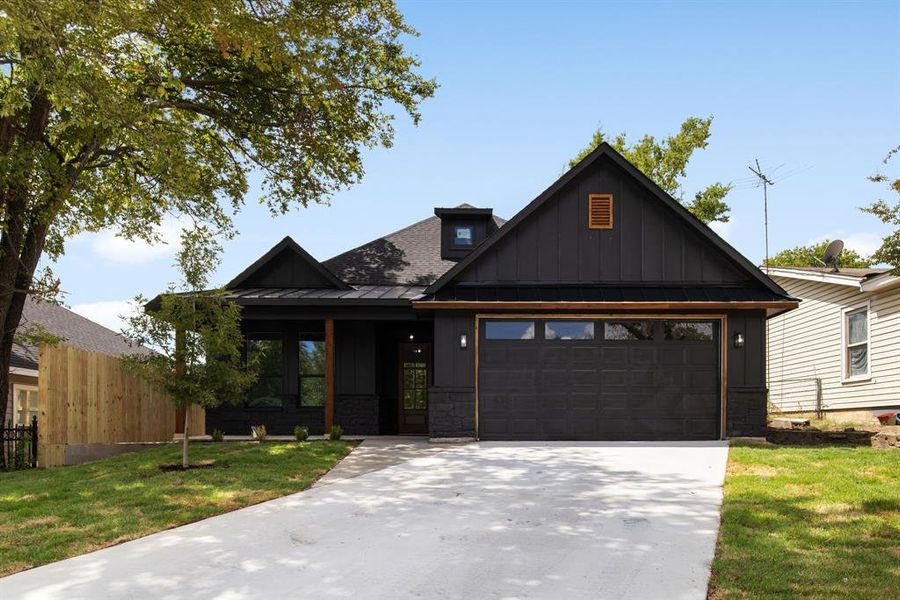 View of front of property with a garage and a front yard