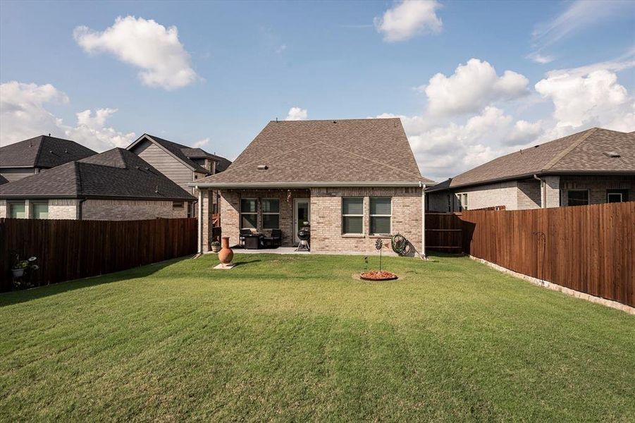 Back of property with a patio and a lawn