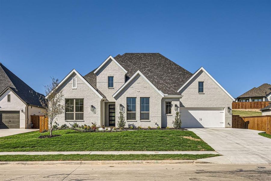 View of front facade featuring a front yard and a garage