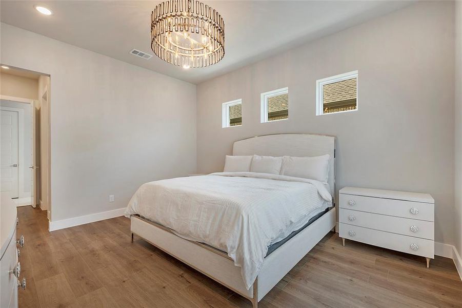 Bedroom with an inviting chandelier and hardwood / wood-style floors