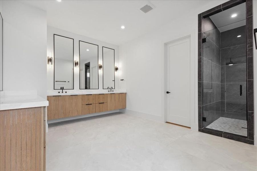 Bathroom featuring tile flooring, a shower with door, and double sink vanity