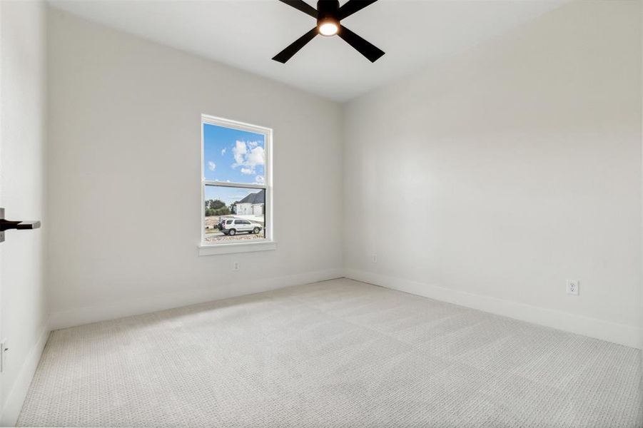 Carpeted empty room with ceiling fan