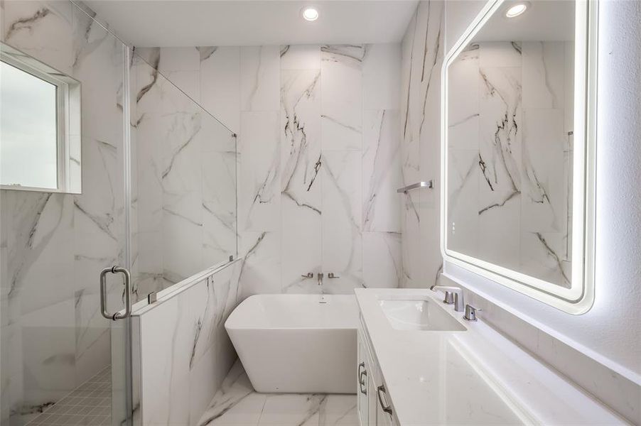 Luxurious primary bath has a freestanding soaking tub large shower and double vanity.