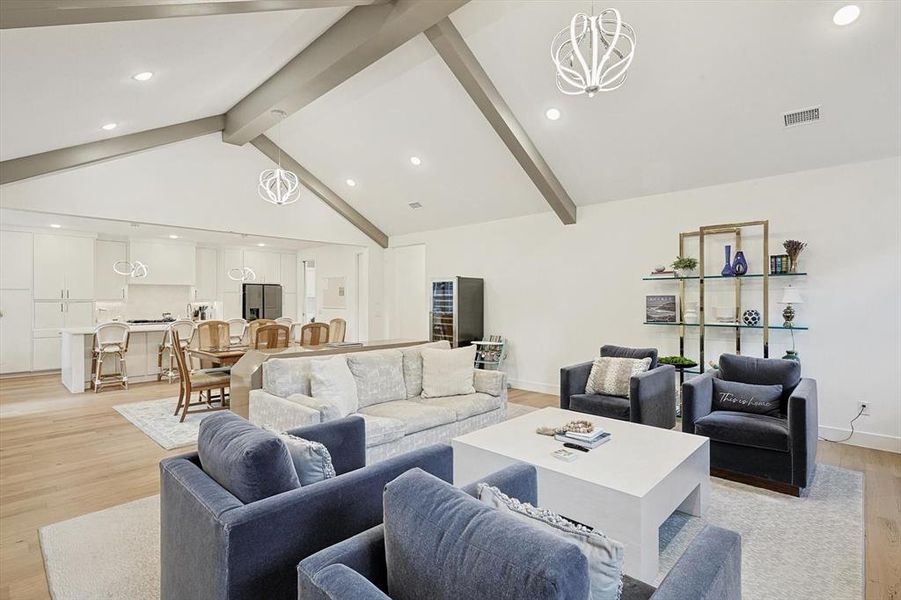 Living room with beam ceiling, high vaulted ceiling, and light hardwood / wood-style floors