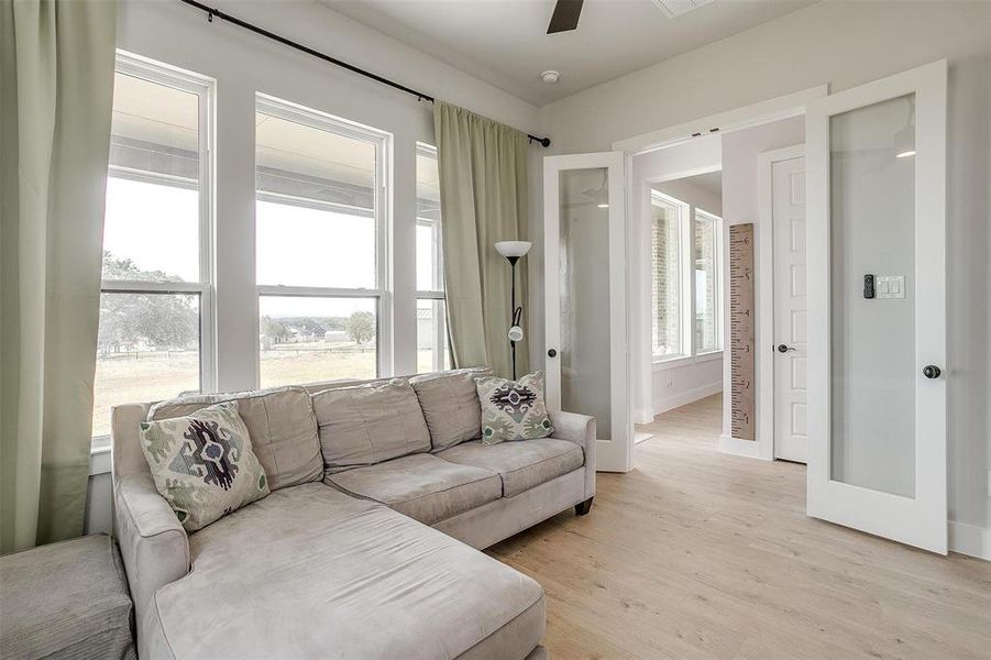 Living room with light hardwood / wood-style flooring and ceiling fan