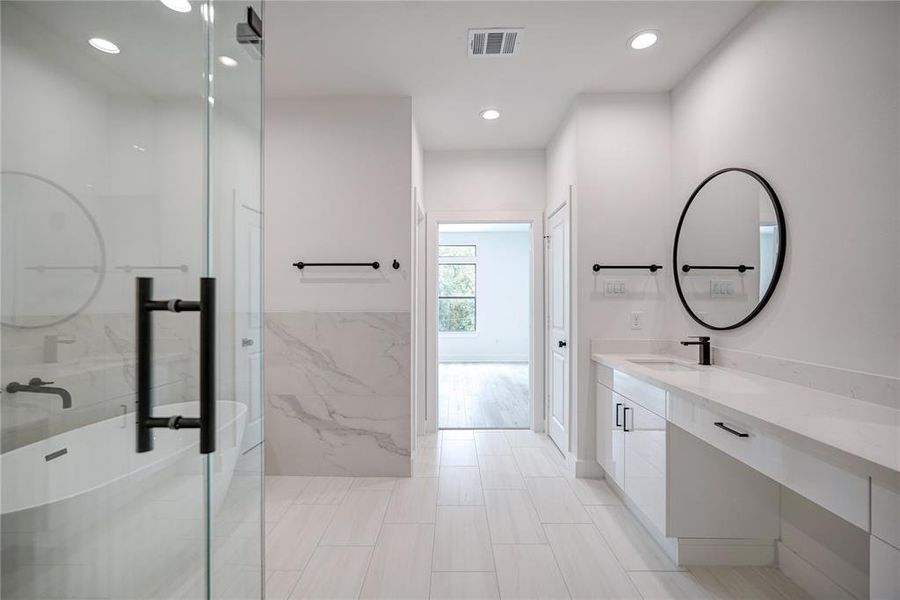 Another view of the primary bathroom showing the frameless shower