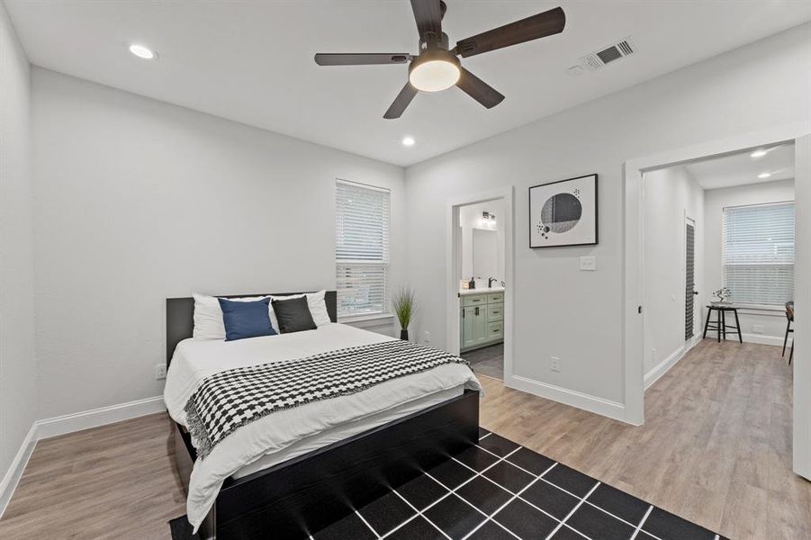 Bedroom with hardwood / wood-style floors, ensuite bathroom, and ceiling fan