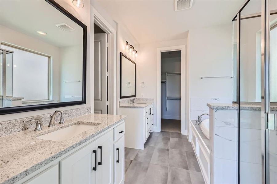 Bathroom with double vanity, tile patterned floors, and separate shower and tub