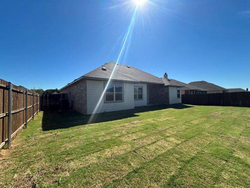 Rear view of house with a yard