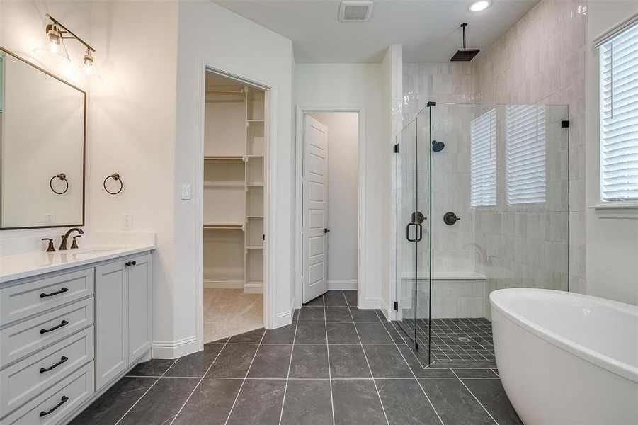 Bathroom featuring independent shower and bath, vanity, and tile patterned flooring