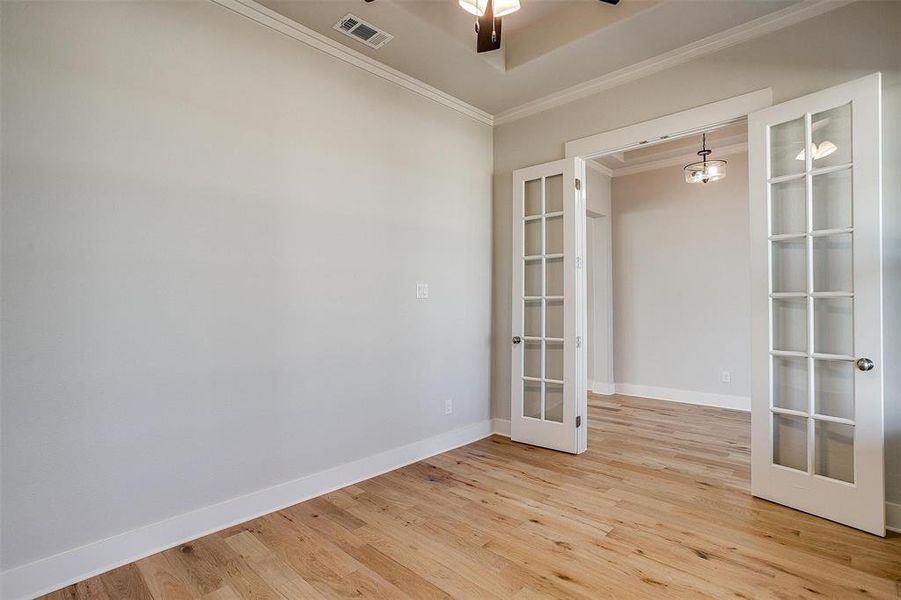 Spare room with light hardwood / wood-style floors, french doors, and ceiling fan