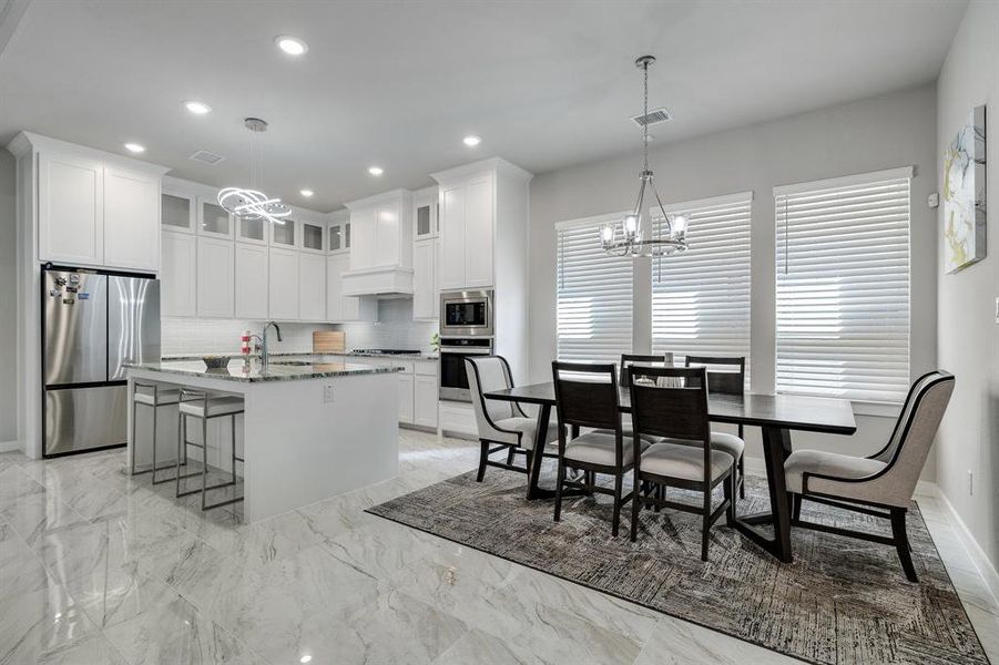 Kitchen with stainless steel appliances, backsplash, light tile patterned floors, and stone countertops