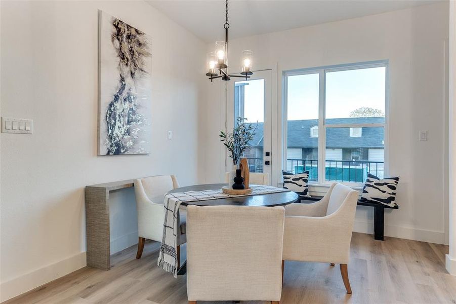 Dining space with a notable chandelier and light hardwood / wood-style floors