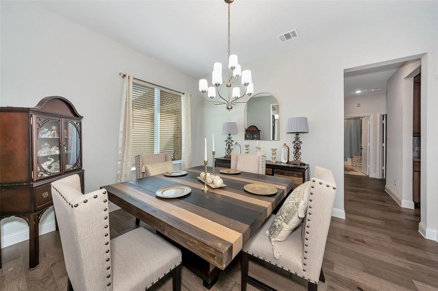 Dining room featuring dark wood-type flooring and a chandelier