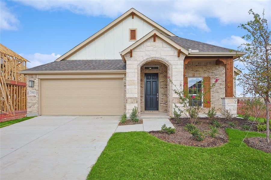 View of front of house featuring a garage and a front yard