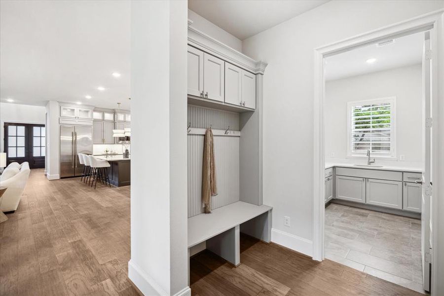 The mudroom is a functional and stylish space, designed for daily convenience. Custom cabinetry with overhead storage and built-in benches with storage below make it the perfect place to drop your belongings as you enter each day. Just ahead is the laundry room.