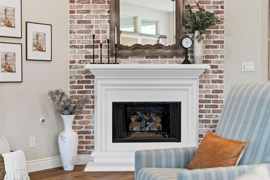 Cast stone fire place with gas logs and brick accent wall