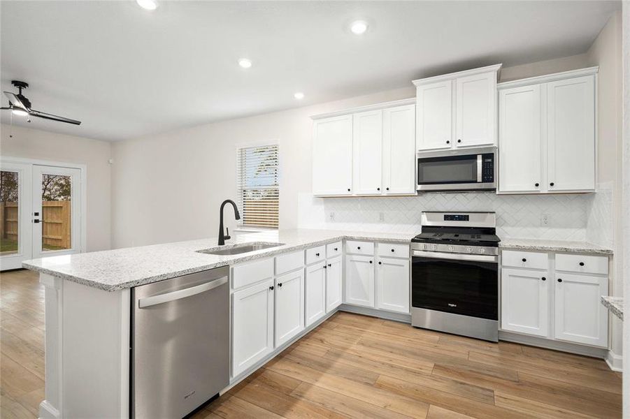 This kitchen is not only spacious, but it also has gorgeous granite countertops, Whirlpool appliances, a farmhouse-style kitchen sink and breakfast bar with space for counter height barstool seating.