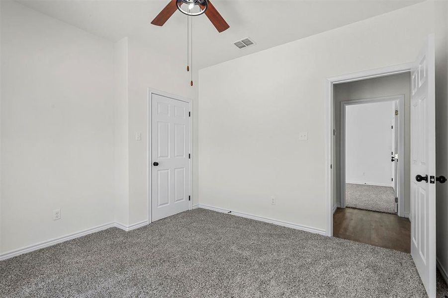 Empty room featuring ceiling fan and dark hardwood / wood-style flooring