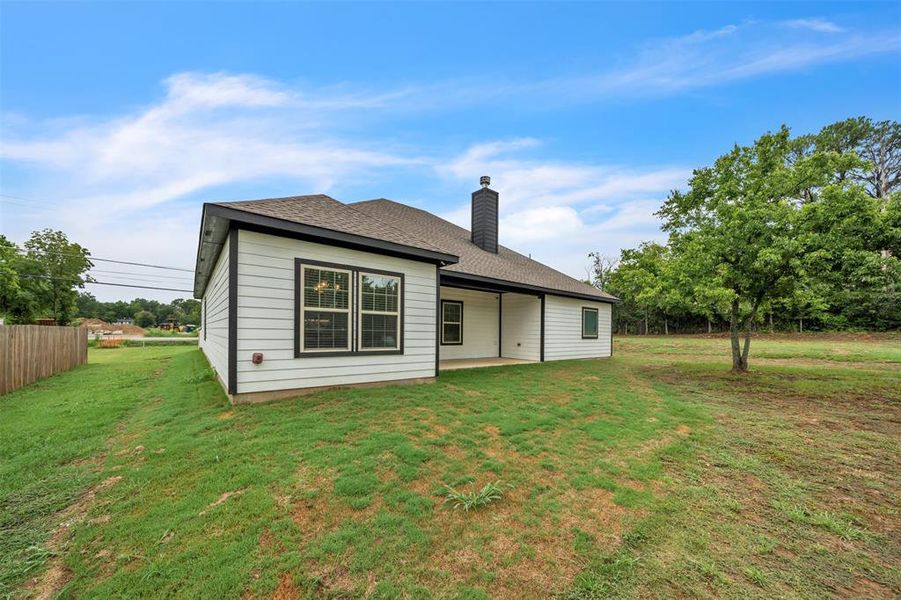 Rear view of house featuring a patio and a yard