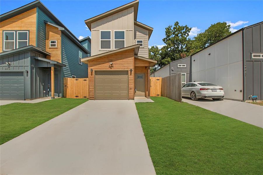 Contemporary house featuring a garage and a front yard