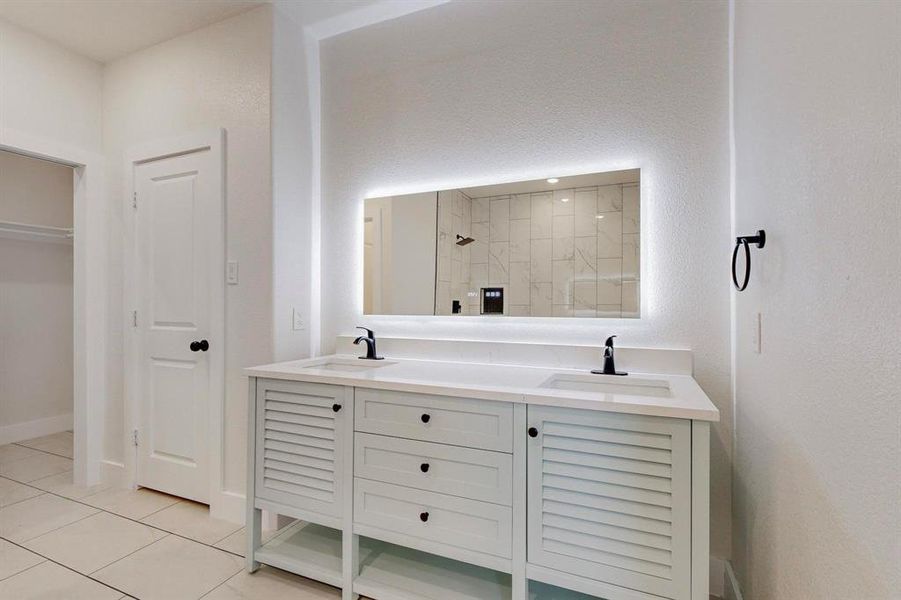 Bathroom with tile floors, oversized vanity, and double sink
