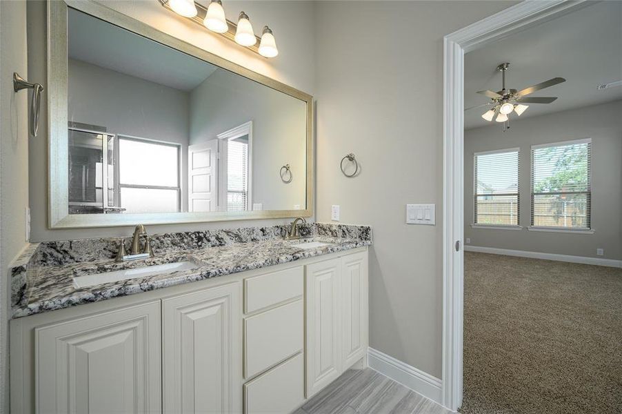 Bathroom featuring dual vanity and ceiling fan