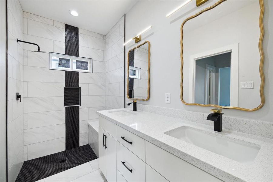 Walk-in shower in the primary bath with rainfall showerhead and built-in bench.