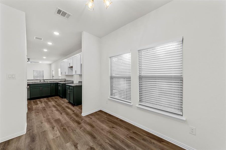 Kitchen with white cabinets, ceiling fan, hardwood / wood-style flooring, sink, and green cabinetry