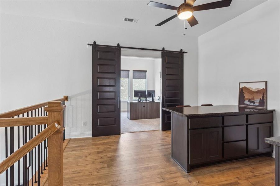 Custom black barn doors open to reveal custom designed office/media flex space