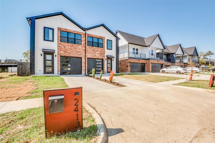 View of front of home featuring a garage and a balcony