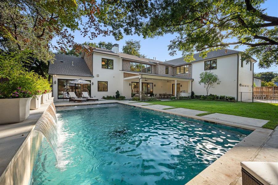 View of pool featuring a patio, a yard, and pool water feature