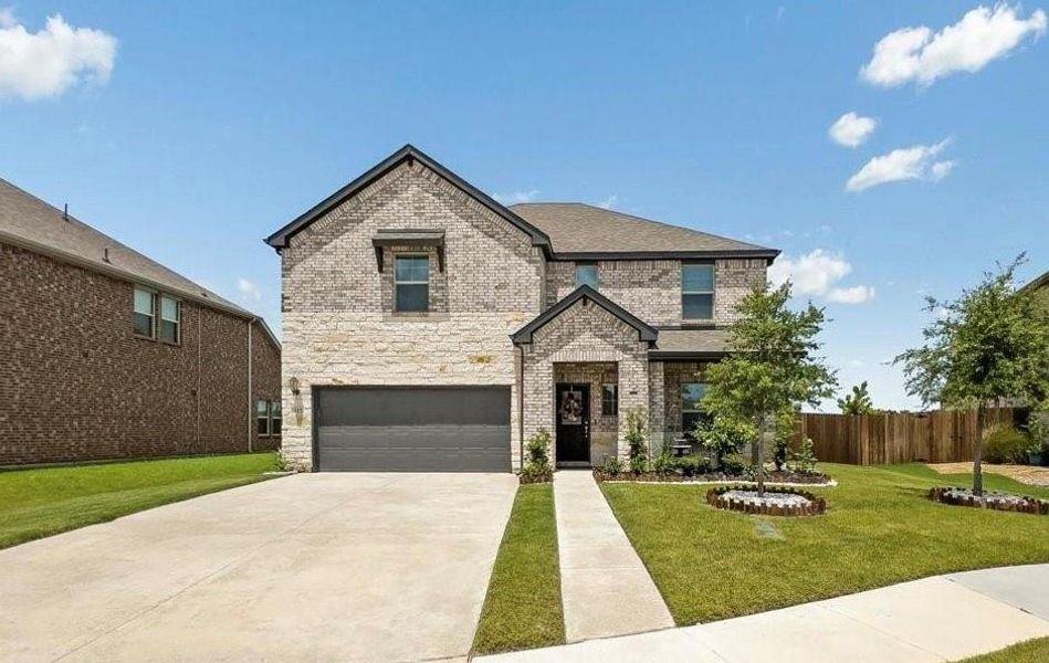 View of front of property featuring a front lawn and a garage