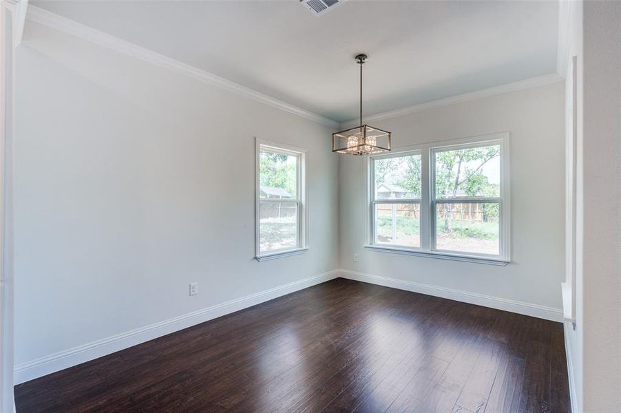 Office/Spare room featuring a notable chandelier, hardwood / wood-style floors, and plenty of natural light