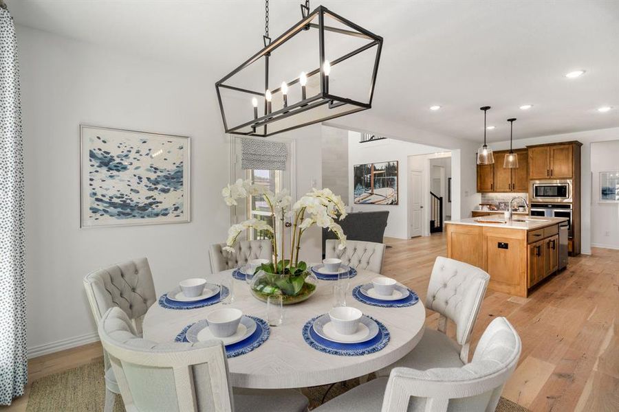 Dining space with an inviting chandelier and light wood-type flooring