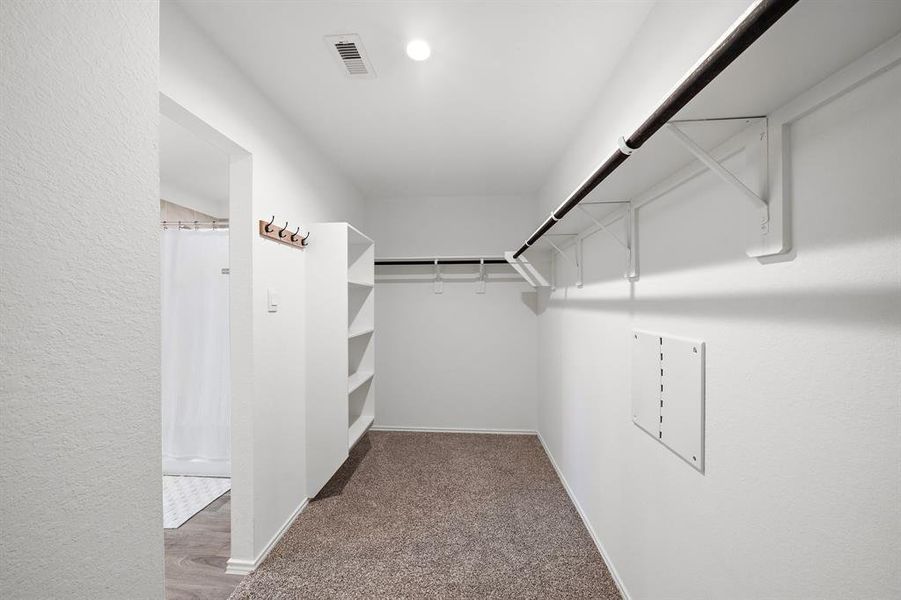 Around the corner from the primary bathroom is the massive walk in closet ready for you to fill.