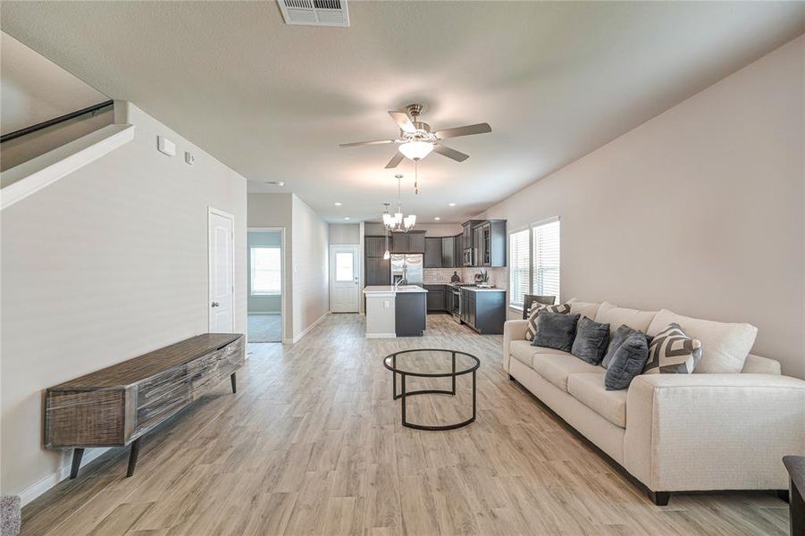 Natural light pours in through two windows, highlighting the light wood-like flooring and creating a bright, inviting space.