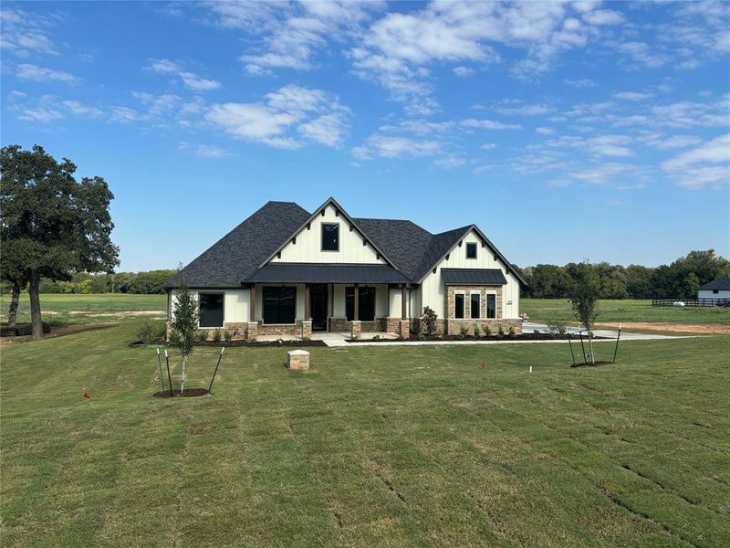 View of front of home featuring covered porch and a front yard