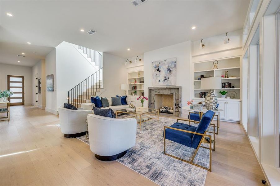 Living room with light wood-type flooring and built in features