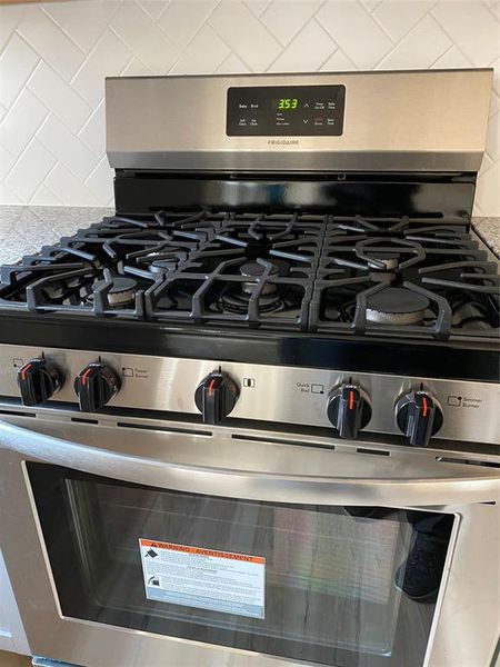 Upgraded five burner gas range with oven and stovetop lights.