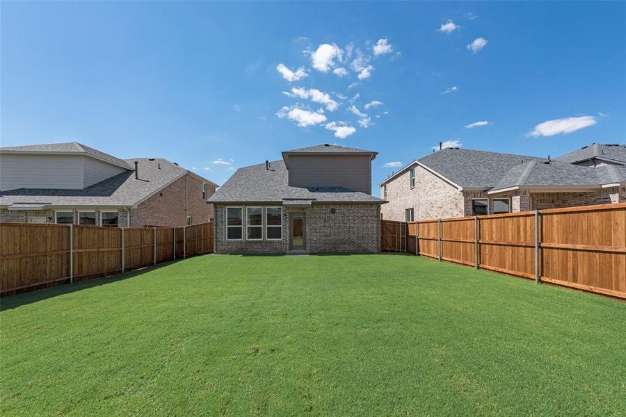 Back of house featuring a yard